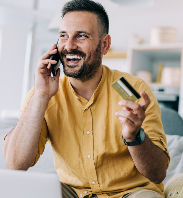 Man smiles and holds a credit card