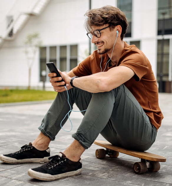 RAIC Insights, Trolle - Mann sitzt auf Skateboard und schaut in sein Handy